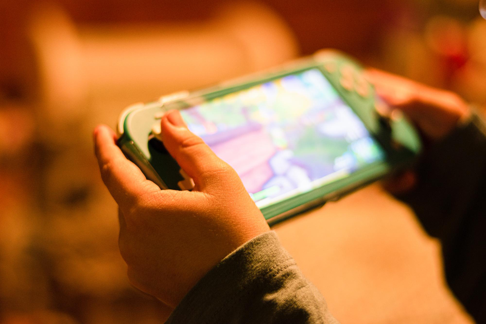 A child holding and playing a game console